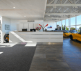 Car showroom with reception desk, flowers, yellow sports cars