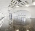 spacious room with marble floor, arched ceiling, multiple windows, and modern lighting fixtures