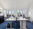 modern office space with desk, chairs, monitor, keyboard, windows, plant