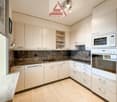 modern kitchen, white cabinets, granite countertops, stainless steel sink, dishwasher, microwave, oven, marble flooring