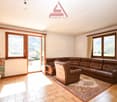 open space, large fireplace, windows to balcony, brown leather sofa, wooden chair