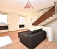 empty, wooden floors, two large windows, sofa, stairs to the upper floor