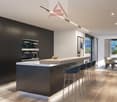 Modern kitchen with black cabinetry, white countertop, stainless steel faucet, large windows with outdoor view