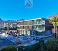 Under construction modern house, brown facade, glass windows, mountains in background