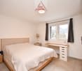 Double bed, wooden nightstands, desk, lamps, window with curtains, tiled floor, ceiling light