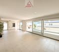 large room, white tile flooring, large glass doors, balcony, potted plant