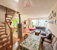 Living room with wooden staircase, white walls, dining table, sofa, rug, fireplace, wall plates