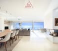 modern living room with large windows, fireplace, dining table, couch, TV, rug, picture frame