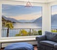 large windows, balcony, couch, ottoman, lake view, mountains