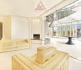 modern living room with fireplace, white tiles, glass walls, white couches, table, view