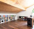wooden ceiling, wooden floor, bookshelves, desk, chair, plant, cat house