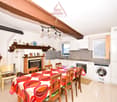 Dining room with a fireplace, a dining table, chairs, a washing machine, and a kitchen area with a sink and a stove