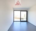 empty room, white walls, gray floor, sliding glass door, balcony