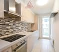 modern kitchen with wooden cabinets, granite countertop, gas stove, oven, sink, faucet, balcony