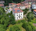 Multiple residential buildings, red roofs, solar panels, green areas, roads, cars parked