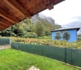 overlooking the garden with green fencing, blue house in the background, mountain landscape