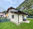 Detached house in the town of Poschiavo, canton of Graubünden, Switzerland, a garden with a gray armchair, located near the Bernina Pass and the Engadin valley.