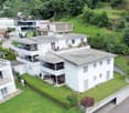 multi-storey house, white exterior, multiple balconies, garden, green surroundings