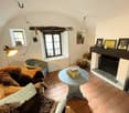 vaulted ceiling, fireplace, small windows, woven chair, wicker sofa with fur blanket