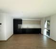 empty kitchen with wooden floor, modern cabinets, large window, built-in oven and sink