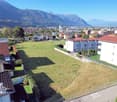 Flat terrain, grass, residential buildings, town, mountains in background