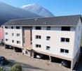 3 story apartment building, white exterior, multiple windows, underground parking, mountain view