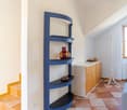 modern room with wooden floor, white and yellow walls, modern shelf, wooden cabinet, radiator, window, stairs