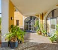 covered patio with various potted plants and an arched doorway with glass doors