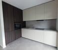 Modern kitchen with white cabinets, dark wood cabinets, built-in oven, and a dishwasher