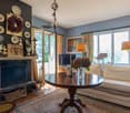 blue walls, fireplace, couch, armchair, round table, lamps, TV, decorations, rug