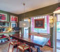 dining table, chairs, wooden shelves, paintings on the wall, floor lamp, radiator, glass doors to balcony