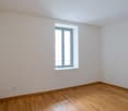 empty room, white walls, wooden floor, window with balcony, power outlets