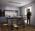 Modern kitchen with gray cabinets, marble backsplash, wooden countertop, and bar stools. The kitchen features a dishwasher and track lighting.