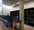 modern office space with large windows, black tables, chairs, and shelves
