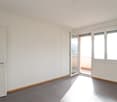 tiled floor, sliding glass door, balcony, white walls, closed door, windows