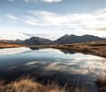pond reflecting the mountains, dry grass