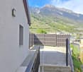House with stone steps leading to the entrance, wall-mounted light, wooden fence, mountain view