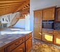 kitchen with wooden cabinets, tiled countertop, oven, fireplace in the corner