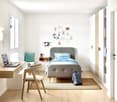 modern room with bed, desk, chair, backpack, rug, open shelving