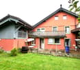2 story house, red brick, white windows, balcony, garden, barrel