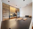 modern kitchen with black countertop, wooden wall cabinets, stainless steel sink, faucet, and appliances