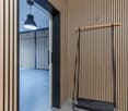 wooden wall, striped pattern, open door, hanging lamp, coat rack