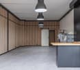 empty room, wooden walls, tiled floor, kitchen area with sink and cabinets