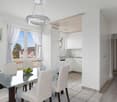 white walls, white ceiling, glass table, 6 chairs, modern chandelier, white kitchen, white radiator, window with white curtains, picture frame, wooden floor