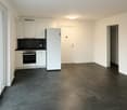White fridge, white built-in kitchen cabinets, black tiled floor, glass door, white wall