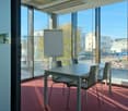 modern design meeting room with glass walls, gray table, gray chairs, whiteboard, red carpet