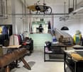 clothing store interior, clothing racks, counter, wooden shelves, bicycle hanging from ceiling, various apparel displayed