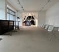 empty hall with white chairs, long desk, curtains