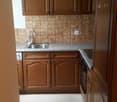 Wooden cabinets, tile backsplash, granite countertop, sink, dishwasher, washing machine