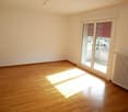 Spacious bedroom with hardwood flooring, large windows, and access to a balcony or terrace.